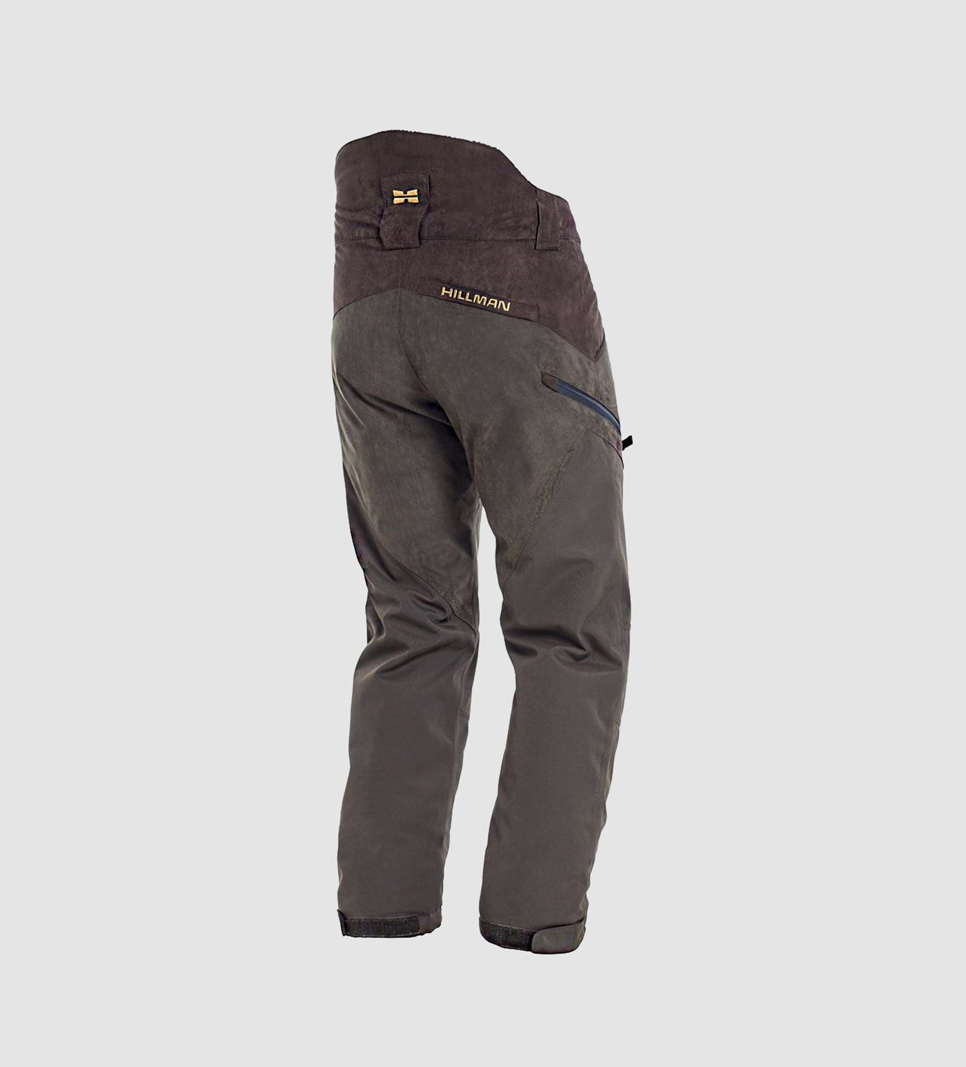 Shown from the back on a plain light gray background, the PRE-ORDER Fusion Waterproof Hunting Pants by Hillman® feature a dark green and brown design, high waist, zippered pocket, waterproof material, and “Hillman®” printed on the back.