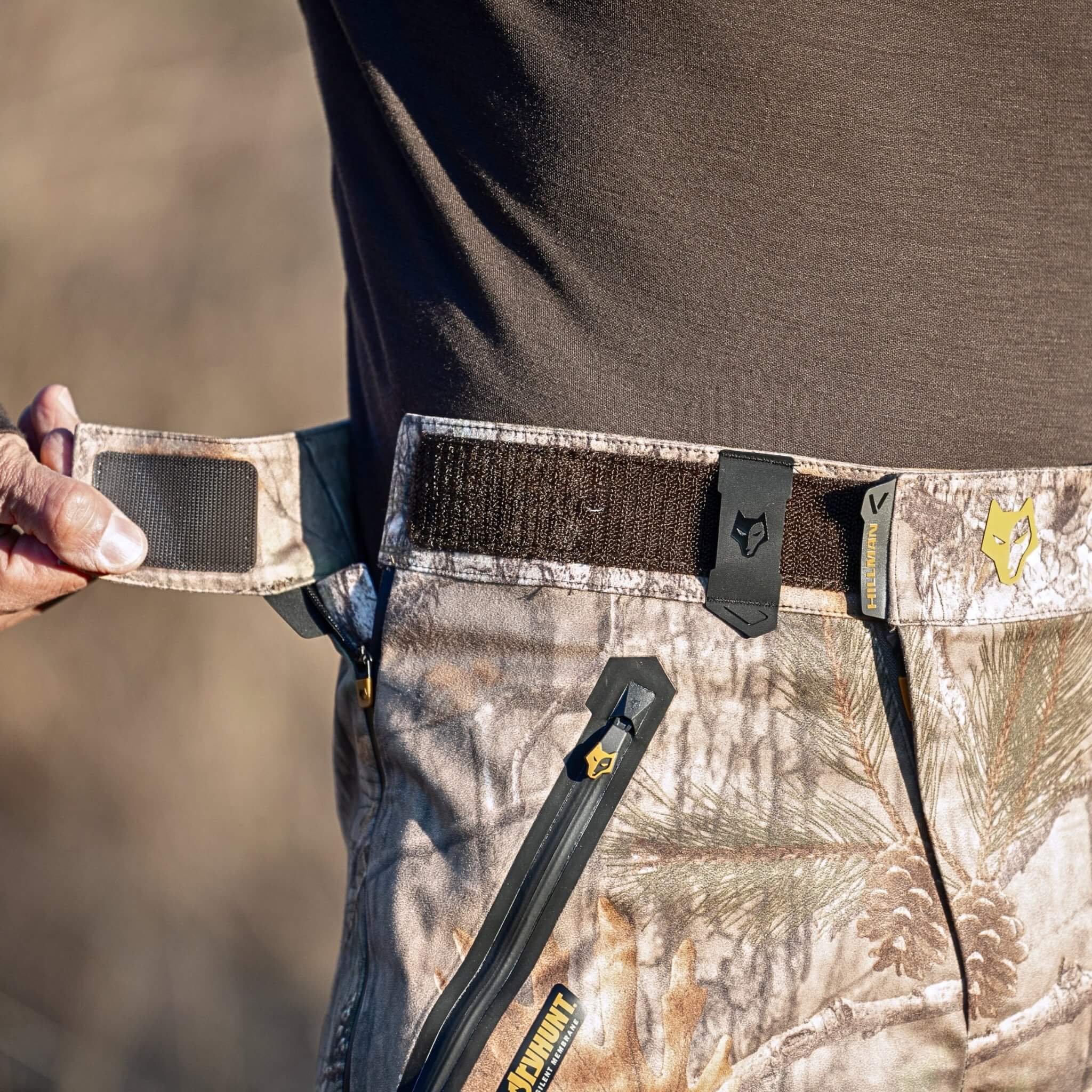 A person wearing HILLMAN GEAR’s Waterproof Camo Pants Lightweight Hunting Rain ProShell 5WL.