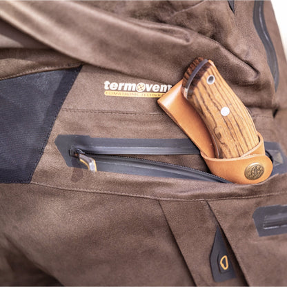 A close-up of a brown pocket with a leather knife sheath and wooden-handled knife, featuring the termovent label—an ideal match for HILLMAN GEAR Insulated Hunting Pants 6OL Cold Weather Waterproof Bibs with Matrix Insulation.