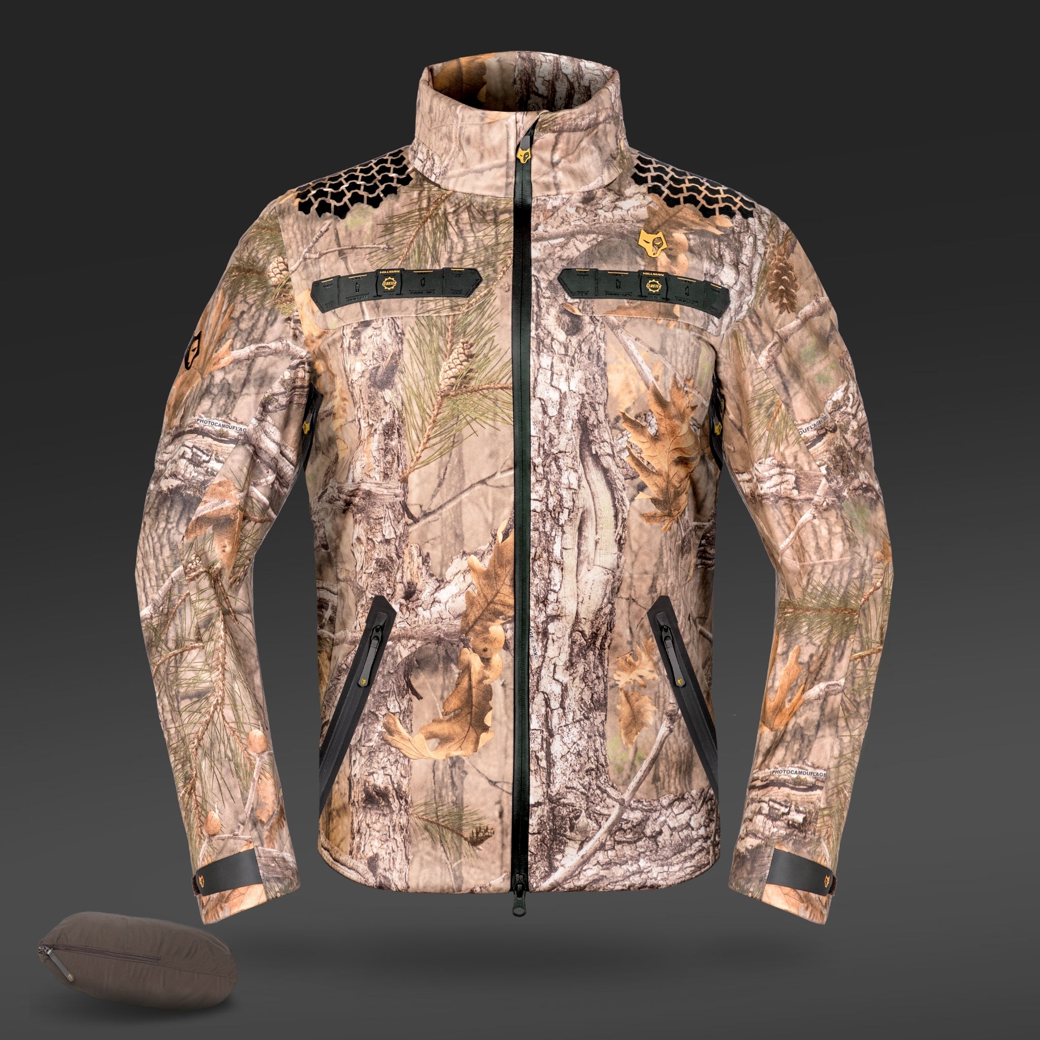 The 5WL Waterproof Camo Hunting Rain Jacket by HILLMAN GEAR, featuring a high collar and zippered pockets, is expertly crafted for blending into natural environments. This breathable jacket is displayed against a dark background with a small matching pouch in the bottom left corner.