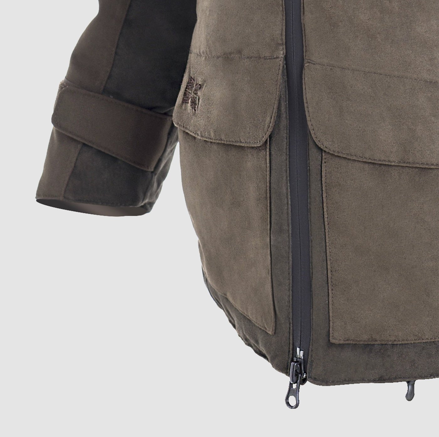 Close-up of the Hillman® PRE-ORDER Fusion Hunting Jacket in brown suede, showing a front zipper, large flap pocket, and sleeve with cuff strap. The jacket is set against a plain light gray background.