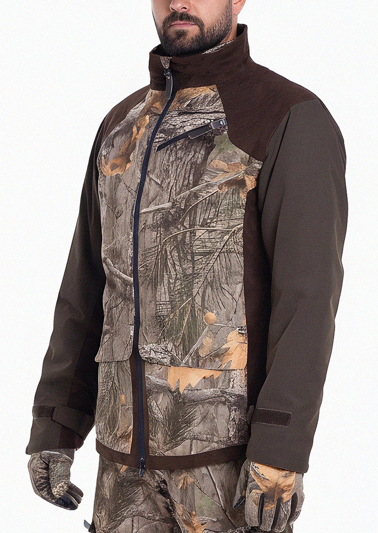 A person wears the Hillman® Waterproof Insulated Hunting Jacket | Fusion, featuring brown sleeves, a leaf-pattern camo design, front zipper, and large pockets—perfect for cold-weather hunts. Matching camo pants and gloves complete the outfit; face partially visible.